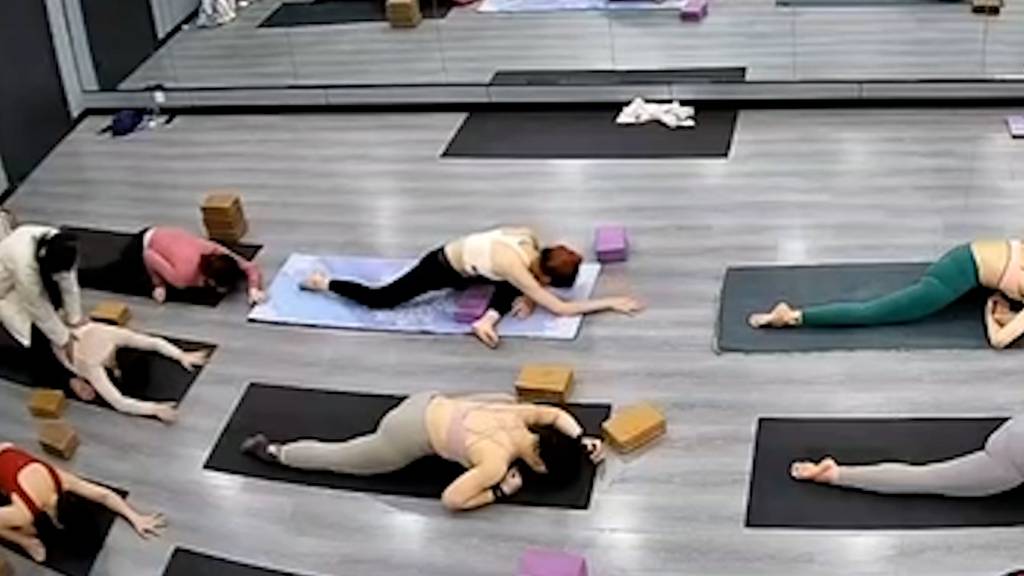 Lehrerin hilft beim Dehnen - Frau bricht sich Oberschenkel beim Yoga