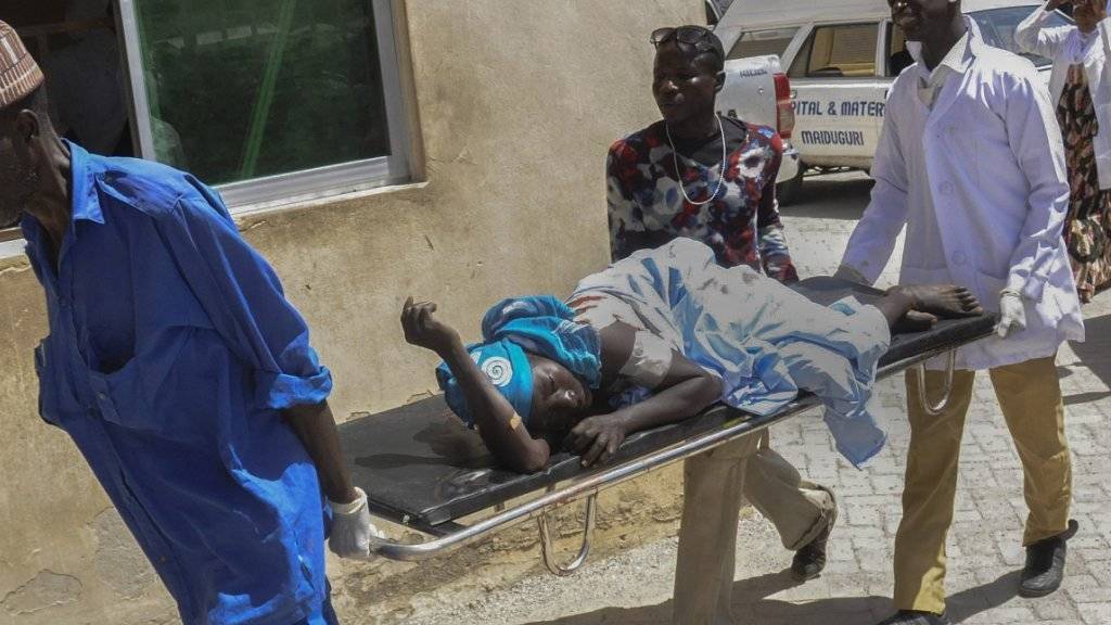 Rettungskräfte bringen einen Verletzten nach dem Bombenanschlag im Nordosten Nigerias in Sicherheit (Archivbild).