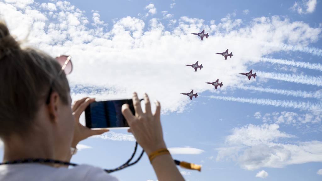 Eine Zuschauerin fotografiert am 1. September 2023 die Flugshow der Patrouille Suisse anlässlich des 75-Jahre-Jubiläums des Flughafens Zürich. (Archivbild)