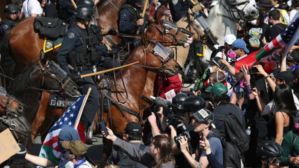 Demonstranten stoßen in Los Angeles mit berittenen Polizisten zusammen. Foto: Ethan Swope/AP/dpa/Archivbild
