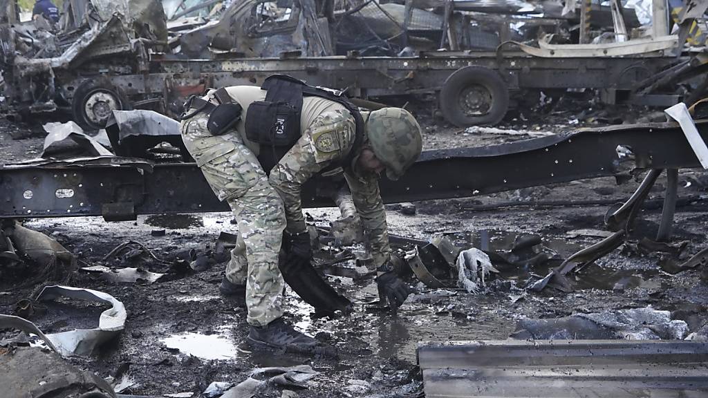 Ein Polizeibeamter sammelt Beweise nach einem russischen Angriff. Foto: Andrii Marienko/AP/dpa