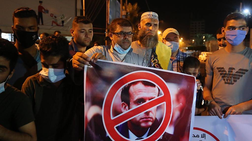 Ein Palästinenser hält bei einer Protestaktion ein Anti-Macron-Plakat. Foto: Ashraf Amra/APA Images via ZUMA Wire/dpa