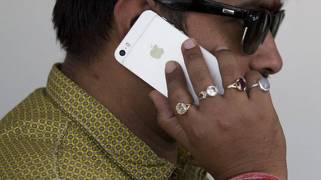 Ein Inder telefoniert mit einem iPhone. Aufgrund von Reformen der indischen Regierung kann Apple nun eigene Läden in Indien eröffnen. (Symbolbild)