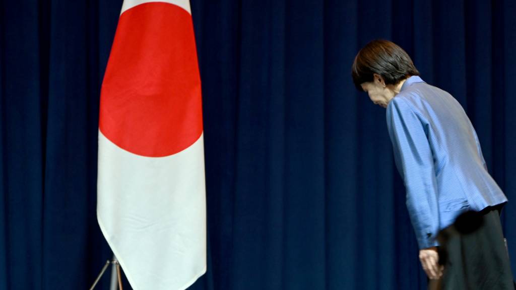 ARCHIV - Sanae Takaichi, Ministerpräsidentin Japans, verneigt sich auf einer Pressekonferenz vor der japanischen Flagge. Foto: Johannes Neudecker/dpa