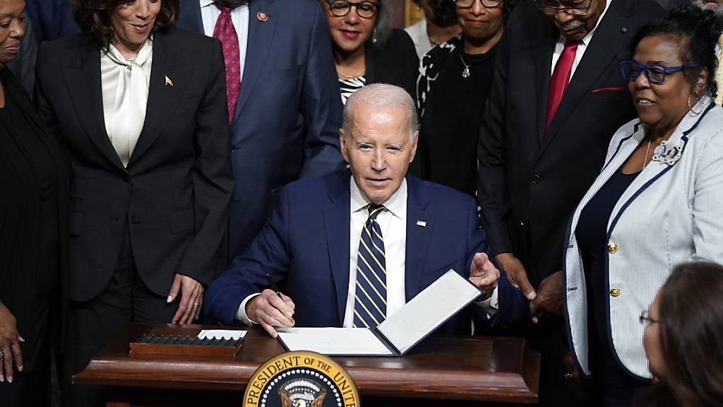 Joe Biden (M), Präsident der USA, unterzeichnet eine Proklamation zur Errichtung des Emmett Till und Mamie Till-Mobley National Monuments im Indian Treaty Room auf dem Campus des Weißen Hauses. Foto: Evan Vucci/AP/dpa