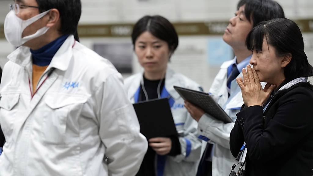 Mitarbeitende der Japan Aerospace Exploration Agency (JAXA) verfolgen die Live-Übertragung der Mondlandung in Sagamihara, Japan. Foto: Eugene Hoshiko/AP/dpa