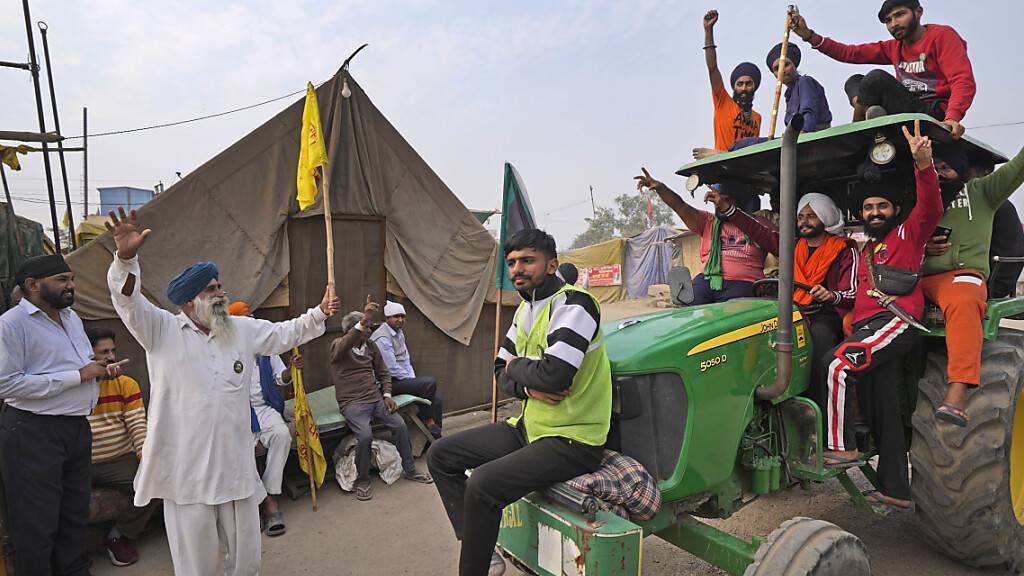 Landwirte feiern die Nachricht von der Aufhebung der Landwirtschaftsgesetze, gegen die sie protestiert hatten. Premierminister Narendra Modi teilte am Freitag mit, dass nach fast einjährigen Protesten die kontroverse Agrarmarktreform zurückgezogen werden soll. Foto: Manish Swarup/AP/dpa