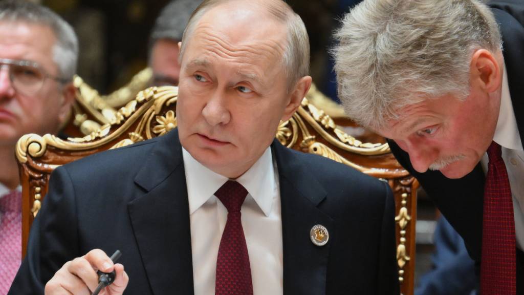 ARCHIV - Der russische Präsident Wladimir Putin (l) spricht mit Kreml-Sprecher Dmitri Peskow während des Gipfels der Gemeinschaft Unabhängiger Staaten im Palast der Nation. Foto: Grigory Sysoyev/Pool Sputnik Kremlin/dpa