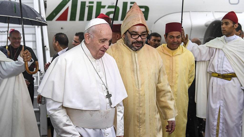 Papst Franziskus wird bei seiner Ankunft auf dem Flughafen von Rabat vom marokkanischen König (rechts vom Papst, in gelblicher Kapuze) begrüsst.