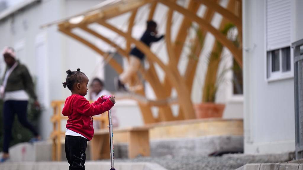 ARCHIV - Ein kleines Flüchtlingskind steht auf einem Tretroller im Aufnahme- und Unterbringungszentrum für Asylbewerber in der Gemeinde Kofinou (Kofinou Reception and Accommodation Centre for Applicants for International Protection) vor Wohncontainern. Foto: Bernd von Jutrczenka/dpa