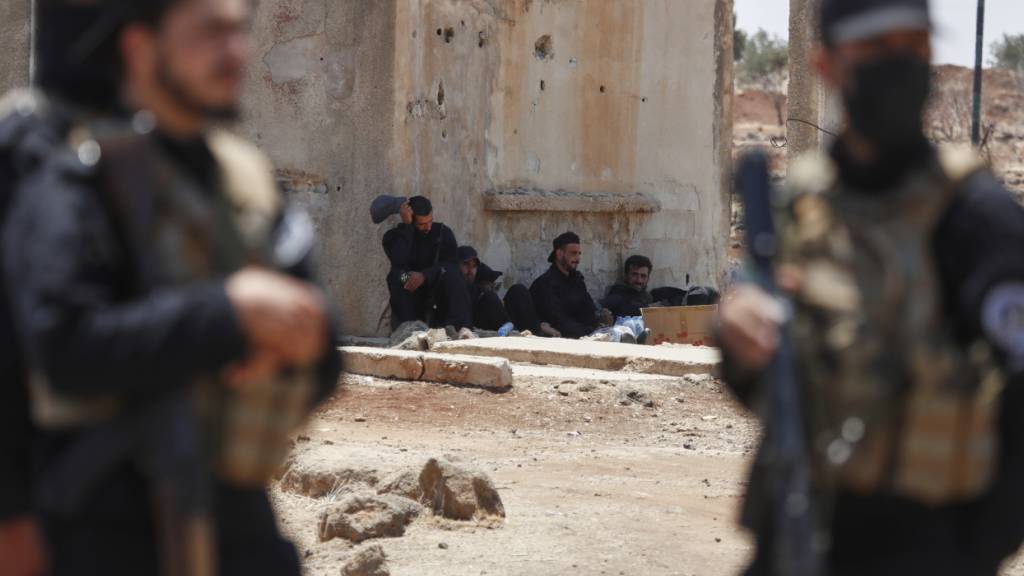 ARCHIV - Syrische Sicherheitskräfte ruhen sich in der Nähe eines beschädigten Gebäudes aus, während sie im Dorf Busra al-Harir im Süden Syriens eingesetzt werden. Foto: Omar Sanadiki/AP/dpa