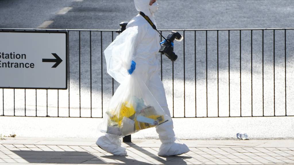 Ein forensischer Ermittler trägt Beweismaterial. Foto: Kirsty Wigglesworth/AP/dpa