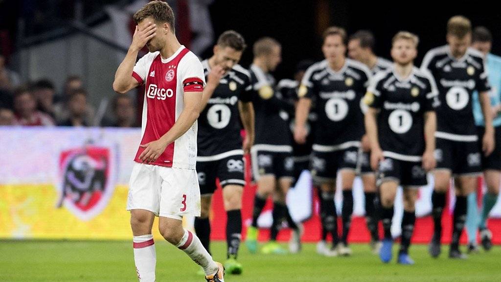 Ajax-Spieler Joel Veltman hält sich die Hände vors Gesicht - hinten die Spieler von Rosenborg Trondheim