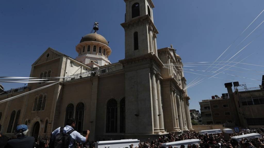 Trauernde tragen Särge der Opfer des Selbstmordanschlag vom Sonntag, 22. Juni 2025, während einer Trauerfeier vor der griechisch-orthodoxen Mar-Elias-Kirche im Stadtteil Al-Duwaila. Foto: Omar Sanadiki/AP/dpa