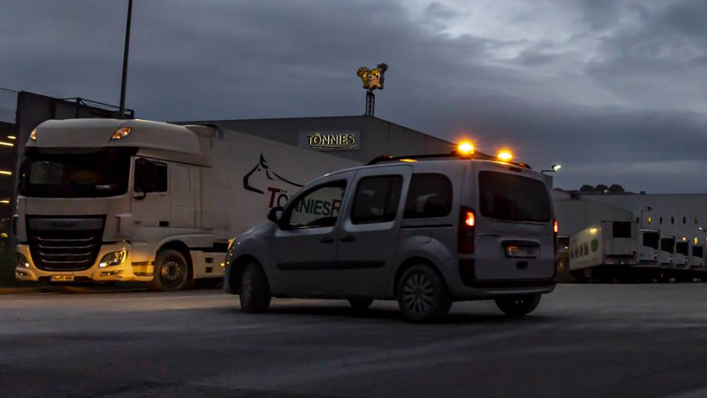 Ein Fahrzeug einer Sicherheitsfirma fährt über das Firmengelände des Fleischwerks Tönnies. Foto: David Inderlied/dpa