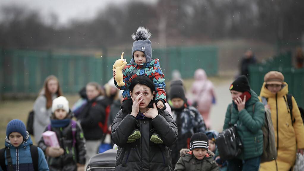 Flüchtlinge, meist Frauen mit Kindern, kommen am Grenzübergang im polnischen Medyka an. Foto: Visar Kryeziu/AP/dpa