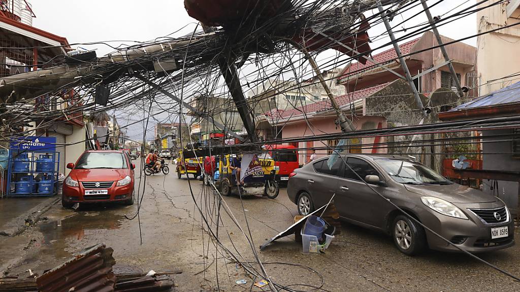 In der Stadt Surigao, Surigao del Norte, sind durch den Taifun «Rai» Strommast umgestürzt. Nach dem heftigen Taifun auf den Philippinen steigt die Zahl der Toten weiter. Neuen Erkenntnissen zufolge seien mindestens 208 Menschen ums Leben gekommen, teilte die Polizei am Montag mit. Foto: Jilson Tiu/AP/dpa