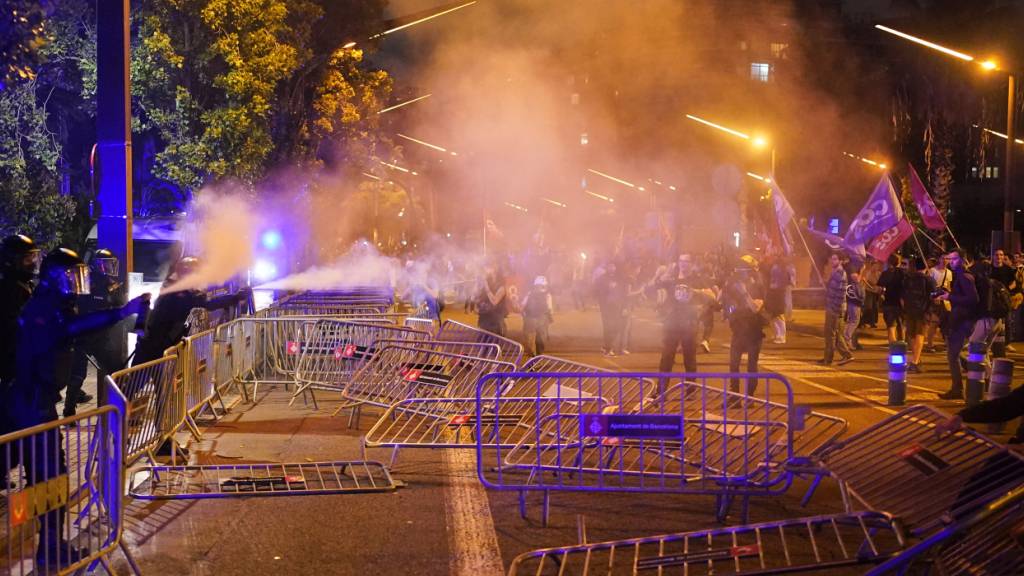Polizisten feuern Tränengas auf Demonstranten in Barcelona. Foto: Bernat Armangue/AP/dpa
