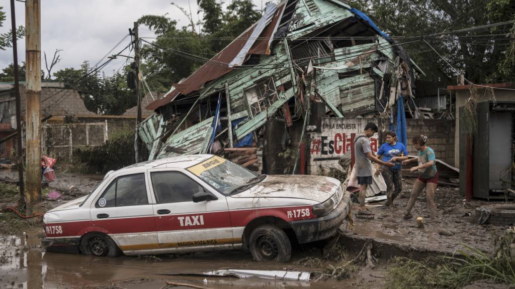 Nachbarn versammeln sich um ein beschädigtes Haus nach heftigen Regenfällen in Poza Rica im mexikanischen Bundesstaat Veracruz. Foto: Felix Marquez/AP/dpa