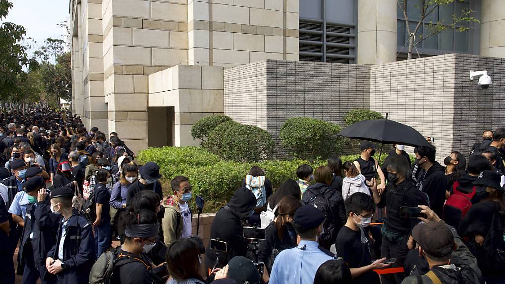 Unterstützer warten vor einem Gericht und versuchen, zu einer Anhörung zu gelangen. Foto: Vincent Yu/AP/dpa