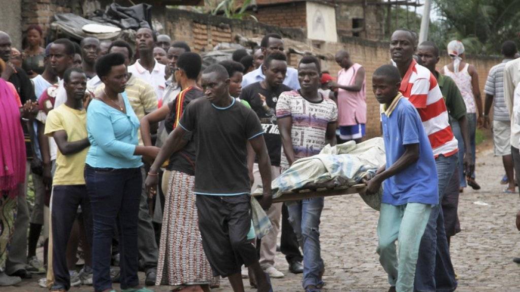 Einwohner der Hauptstadt Bujumbura tragen am Samstag eine Leiche weg.