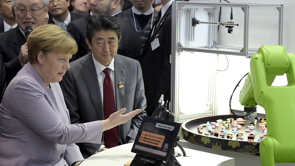 Die deutsche Kanzlerin Angela Merkel und der japanische Ministerpräsident Shinzo Abe auf ihrem Rundgang durch die Messe.