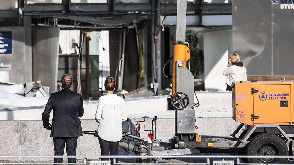 Steuerverwaltungsdirektorin Merete Agergaard und Steuerminister Morten Bodskov begutachten nach einer Explosion die Schäden an der Fassade des Steuerverwaltungsgebäudes in Kopenhagen.