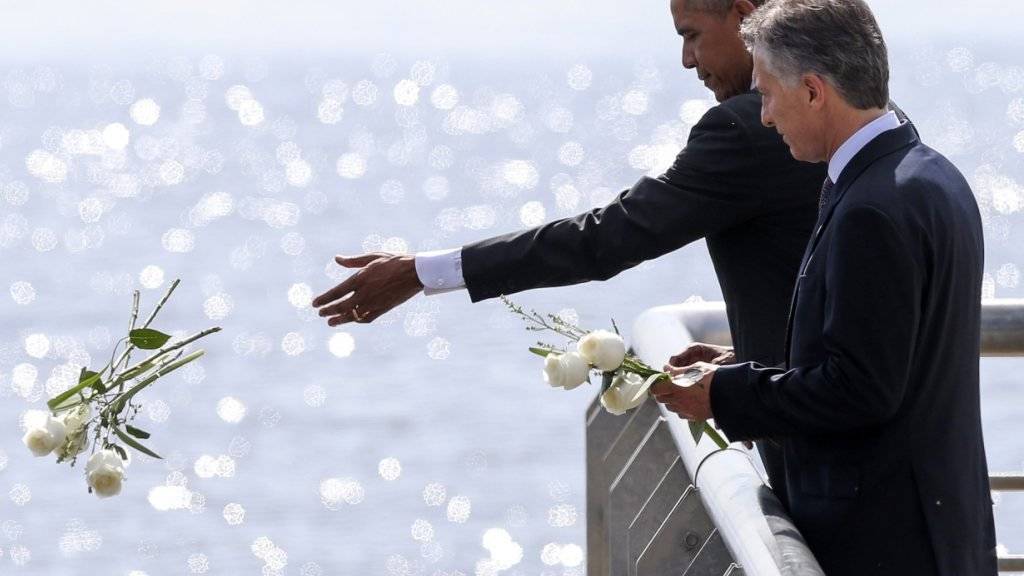 US-Präsident Obama und sein argentinischer Amtskollege Macri werfen an der Gedenkstätte für die Opfer der argentinischen Militärdiktatur Blumen in den Fluss.