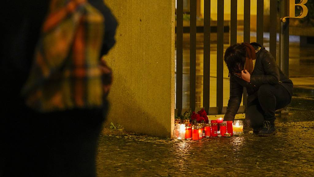 Eine Person entzündet Kerzen vor dem Gebäude der Philosophischen Fakultät der Karls-Universität in der Prager Innenstadt. 