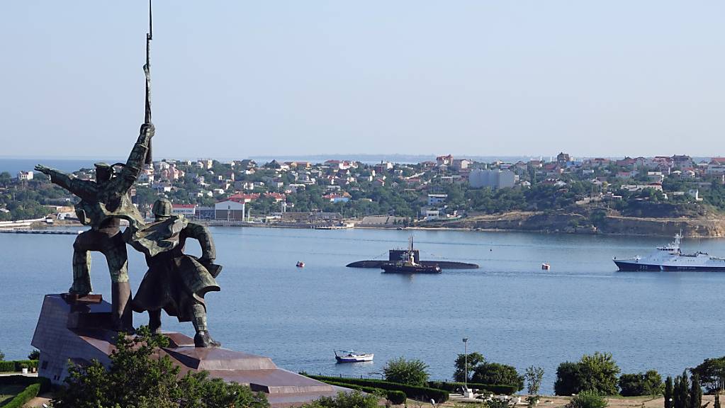ARCHIV - Hinter einem sowjetischen Denkmal liegen ein U-Boot und Kriegsschiffe der russischen Schwarzmeerflotte vor Anker in der Hafenstadt Sewastopol. (Archivbild) Foto: Ulf Mauder/dpa