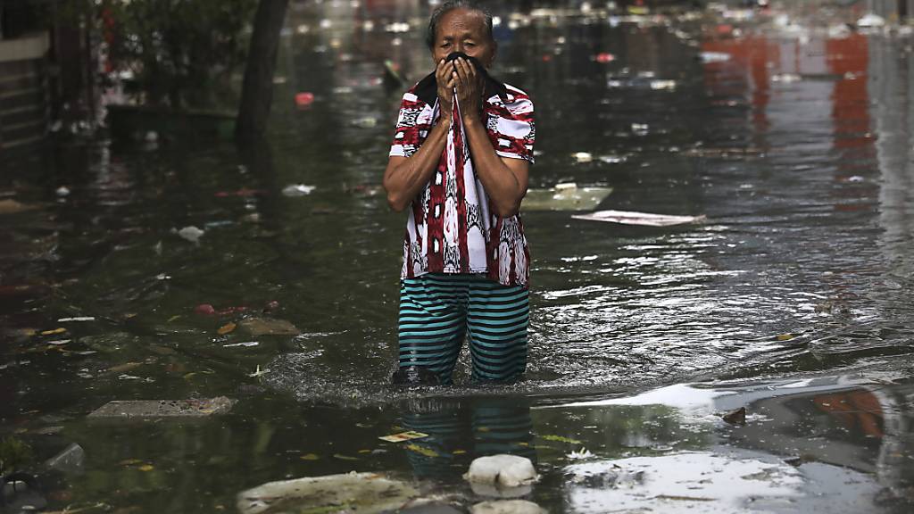 Eine Frau watet am Samstag durch das Wasser in Jakarta, Indonesien. Nach den schweren Überschwemmungen ist die Zahl der Toten auf mindestens 53 gestiegen.
