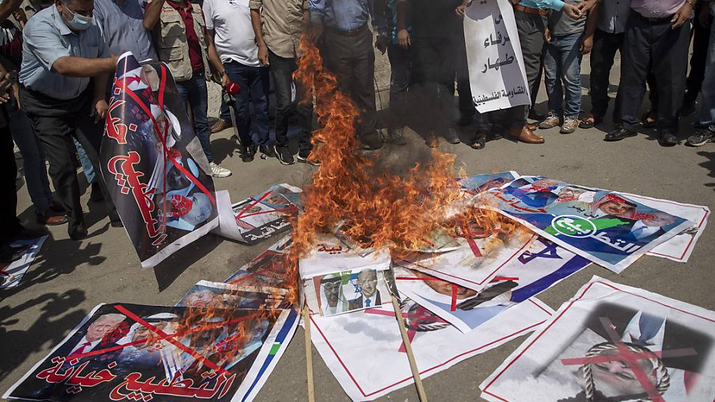 Palästinenser verbrennen Bilder verschiedener Staatsoberhäupter, die planen eine .Vereinbarung zur Aufnahme diplomatischer Beziehungen der Vereinigten Arabischen Emirate (VAE) und Bahrain mit Israel zu unterzeichnen. Foto: Khalil Hamra/AP/dpa