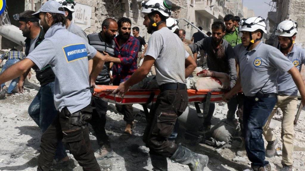 Mitglieder der Hilfsorganisation Weisshelme bringen einen Verletzten in Aleppo in Sicherheit. (Archiv)