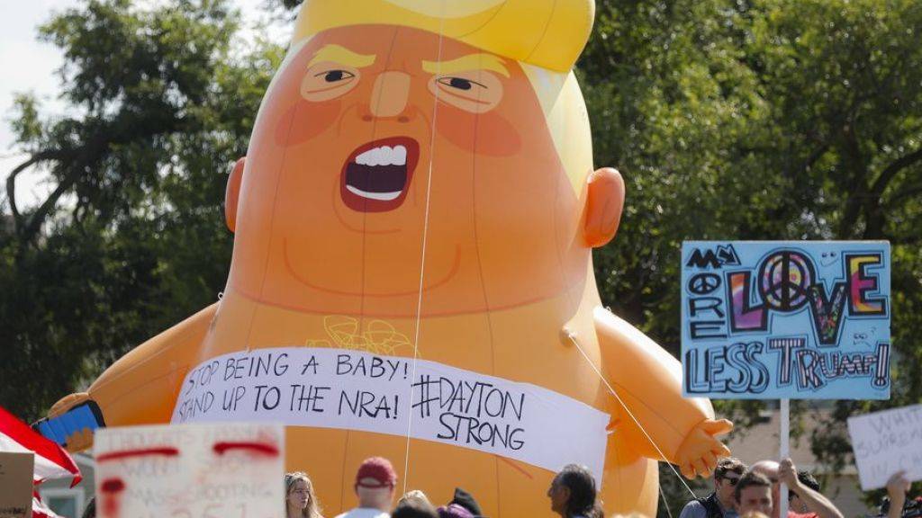 Demonstranten mit dem Baby-Trump-Ballon vor dem Spital, in dem einige der Opfer behandelt und das der US-Präsident besuchte.
