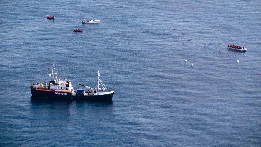 Auf dem von Sea-Eye veröffentlichten Bild vom Samstag ist die Alan Kurdi zu sehen, die sich vor der libyschen Küste einem Schlauchboot mit Flüchtlingen (oben rechts) nähert, während ein angeblich libysches Schnellboot (links oben) die Schiffe umkreist.