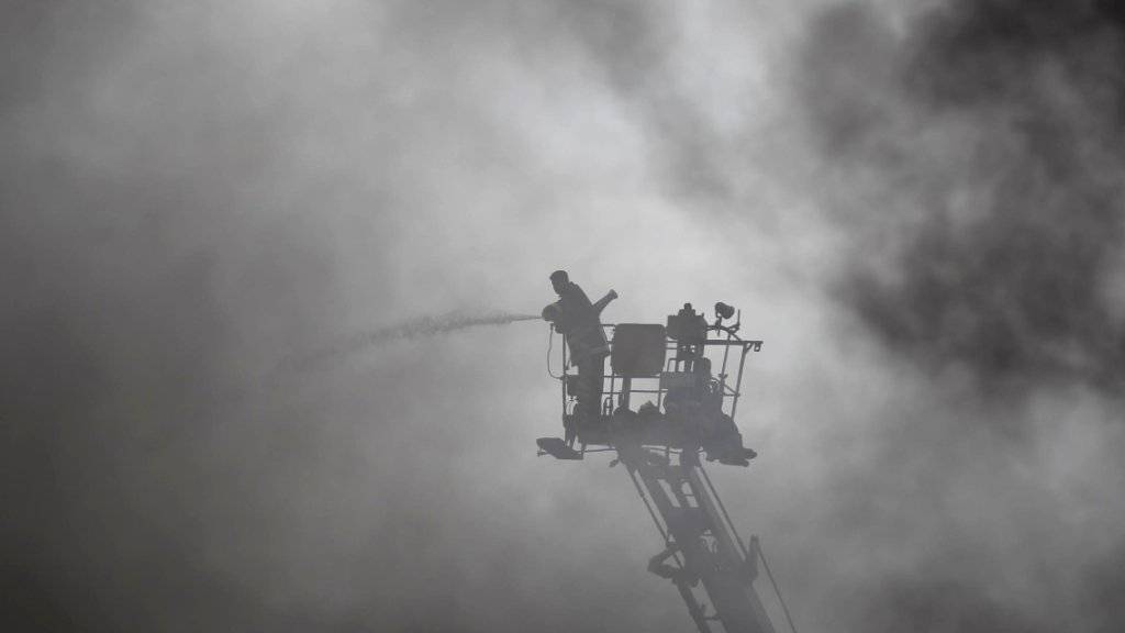 Feuerwehrmann bekämpft das Feuer von hoch oben