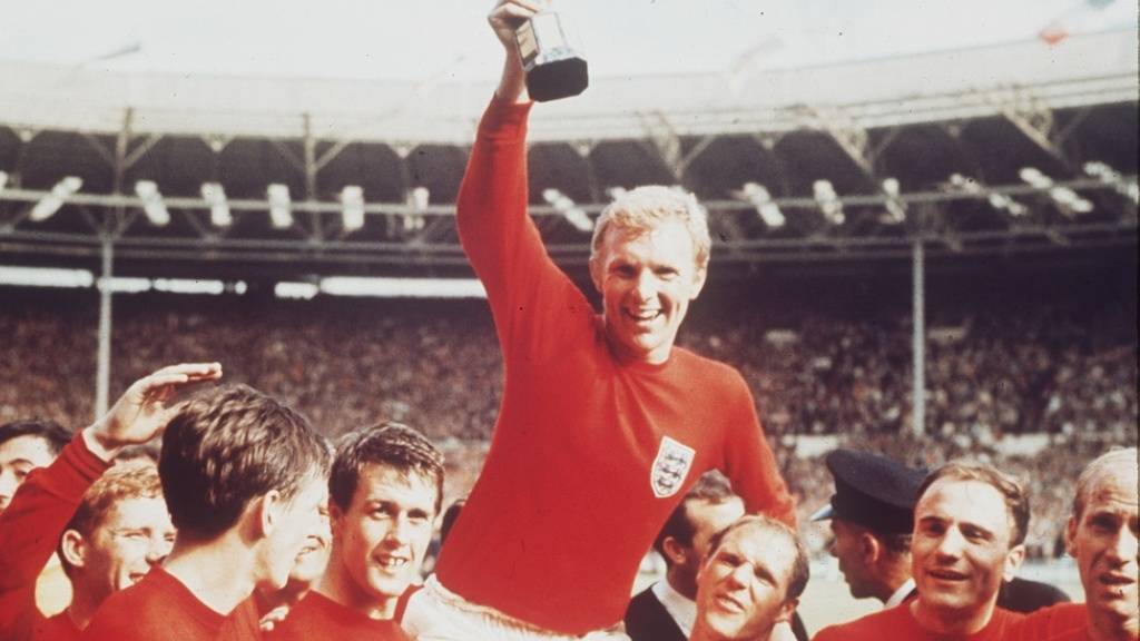 Die britische Fussballmannschaft bejubelt 1966 ihren Weltmeistertitel. Nachdem kürzlich bekannt wurde, dass Bobby Charlton (r) als fünftes Mitglied der damaligen Mannschaft an Demenz erkrankt ist, hat der britische Fussballverband Regeln zur Minimierung von Kopfbällen erlassen (Archivbild).