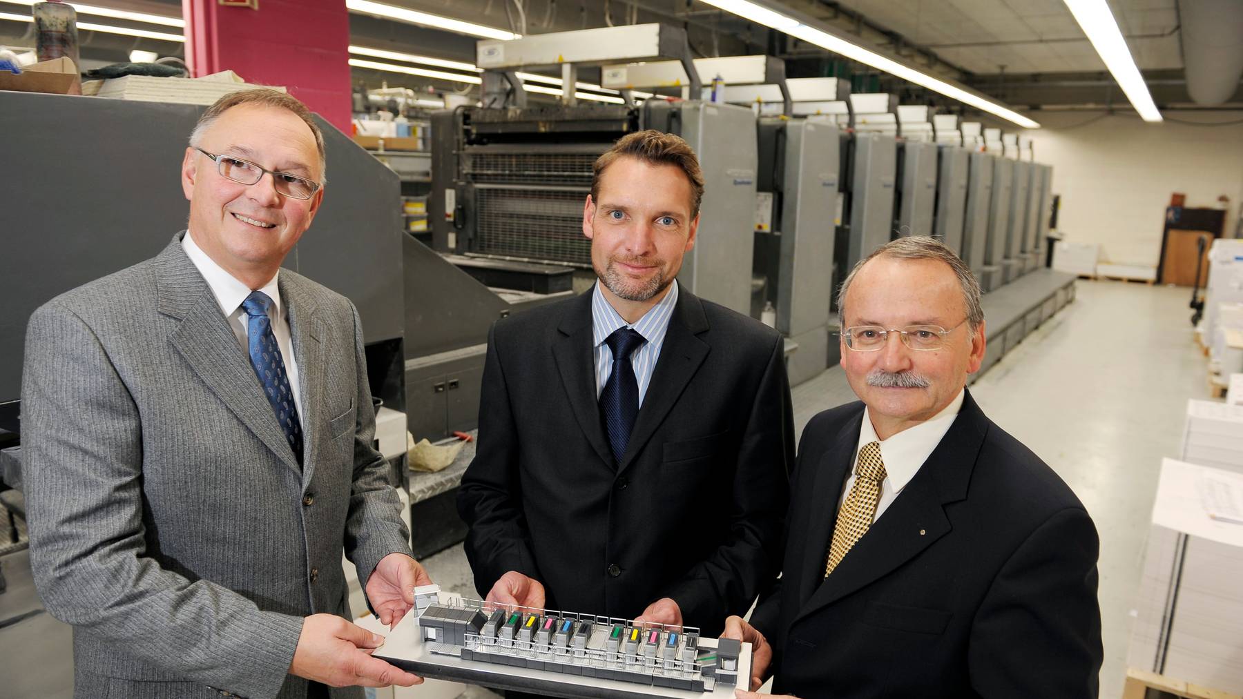Die Multicolor Print AG in Baar: In der Mitte Daniel Ettlinger, heutiger CEO, 2008 bei einer Vertragsunterzeichnung.