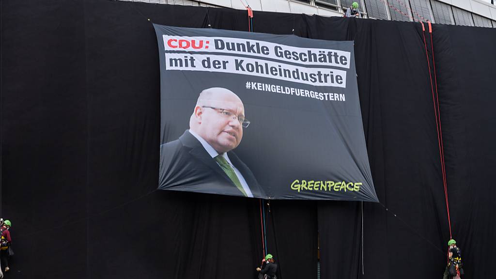 Greenpeace-Aktivisten haben die Parteizentrale der CDU mit schwarzem Stoff verhüllt. Foto: Christophe Gateau/dpa