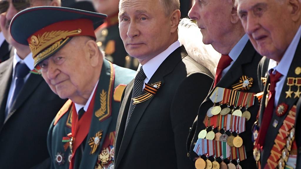 ARCHIV - Russlands Präsident Wladimir Putin (M) verfolgt die Militärparade zum 75. Jahrestag des Sieges der Sowjetunion über Hitler-Deutschland. Foto: Sergei Guneyev/Host Photo Agency/dpa