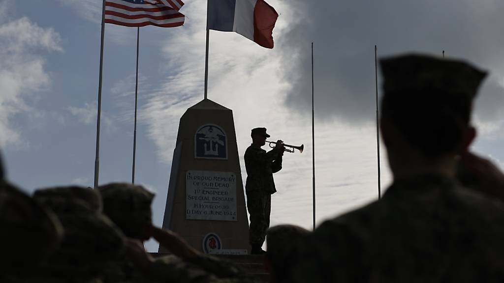 Ein Soldat spielt auf seiner Trompete während einer Kranzniederlegungszeremonie in der Normandie. Veteranen des Zweiten Weltkriegs aus den USA sowie aus Großbritannien und Kanada sind diese Woche in der Normandie, um den 80. Jahrestag der D-Day-Landung zu begehen. Foto: Jeremias Gonzalez/AP/dpa