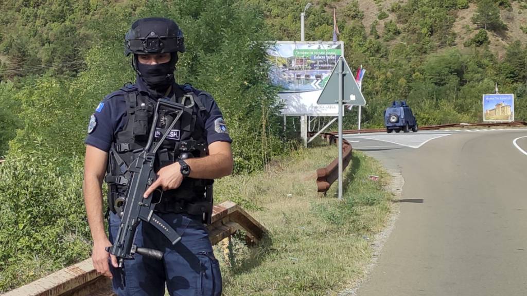 Nach dem Angriff bewachr ein kosovarischer Polizist eine Straße in der Nähe von Banjska, 55 Kilometer nördlich der Hauptstadt Pristina im Norden des Kosovo. Foto: Dejan Simicevic/AP/dpa