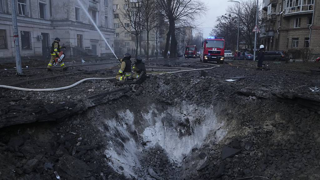 dpatopbilder - Feuerwehrleute arbeiten in der Nähe eines Kraters nach russischen Angriffen. Foto: Vadim Ghirda/AP