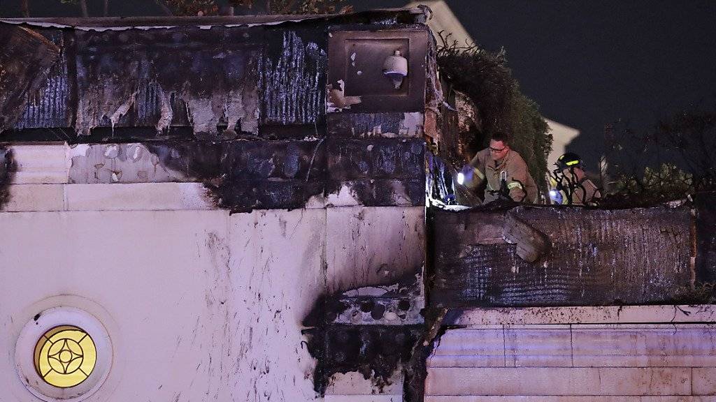 Feuerwehrleute untersuchen den Schaden am Dach des Casinos.
