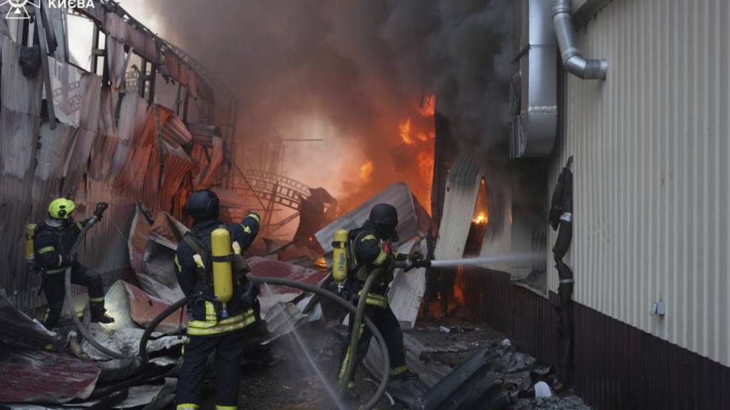 HANDOUT - Rettungskräfte löschen einen Brand nach einem russischen Raketenangriff. Foto: Uncredited/Ukrainian Emergency Service/AP/dpa - ACHTUNG: Nur zur redaktionellen Verwendung und nur mit vollständiger Nennung des vorstehenden Credits