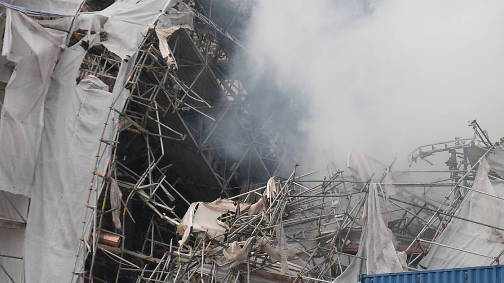 Rauch und Staub umhüllt die Ruinen der alten Börse in Kopenhagen nach dem Brand am 19. April. Foto: Emil Helms/Ritzau Scanpix Foto/AP/dpa