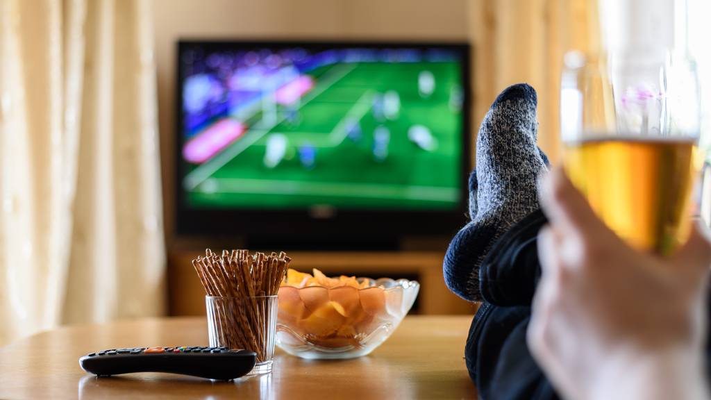 TV Fussball Fernseher Bier Snacks Pommes Chips Stube Wohnzimmer Symbolbild