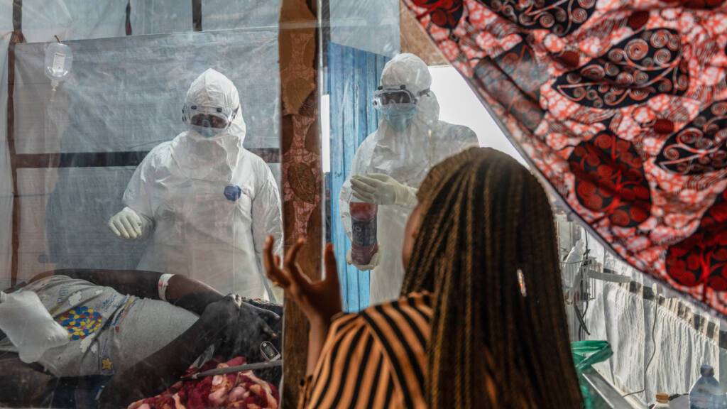ARCHIV - Medizinisches Personal versorgt einen Ebola-Patienten im Behandlungszentrum Rwampara. Foto: Moses Sawasawa/AP/dpa