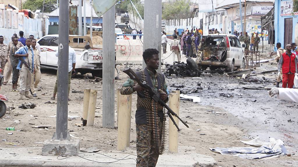 Ein somalischer Soldat steht mit einem Gewehr auf der Straße und sichert das Gebiet nach einem Selbstmordattentat. Bei einem Selbstmordattentat sind in der Hauptstadt des ostafrikanischen Krisenstaates Somalia mindestens 15 Menschen getötet worden, darunter zwei Kinder. Foto: Farah Abdi Warsameh/AP/dpa