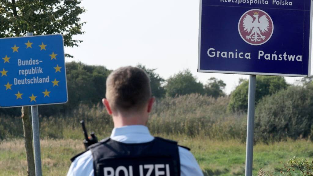 ARCHIV - Bei einer flexiblen Schwerpunktkontrolle unmittelbar an der deutsch-polnischen Grenze in der Nähe des ehemaligen Grenzübergang Linken steht ein Bundespolizist vor den Schildern für Deutschland und Polen. Laut dem Innenminister Christian Pegel zeigen Grenzkontrollen in Mecklenburg-Vorpommern Wirkung. Foto: Bernd Wüstneck/dpa